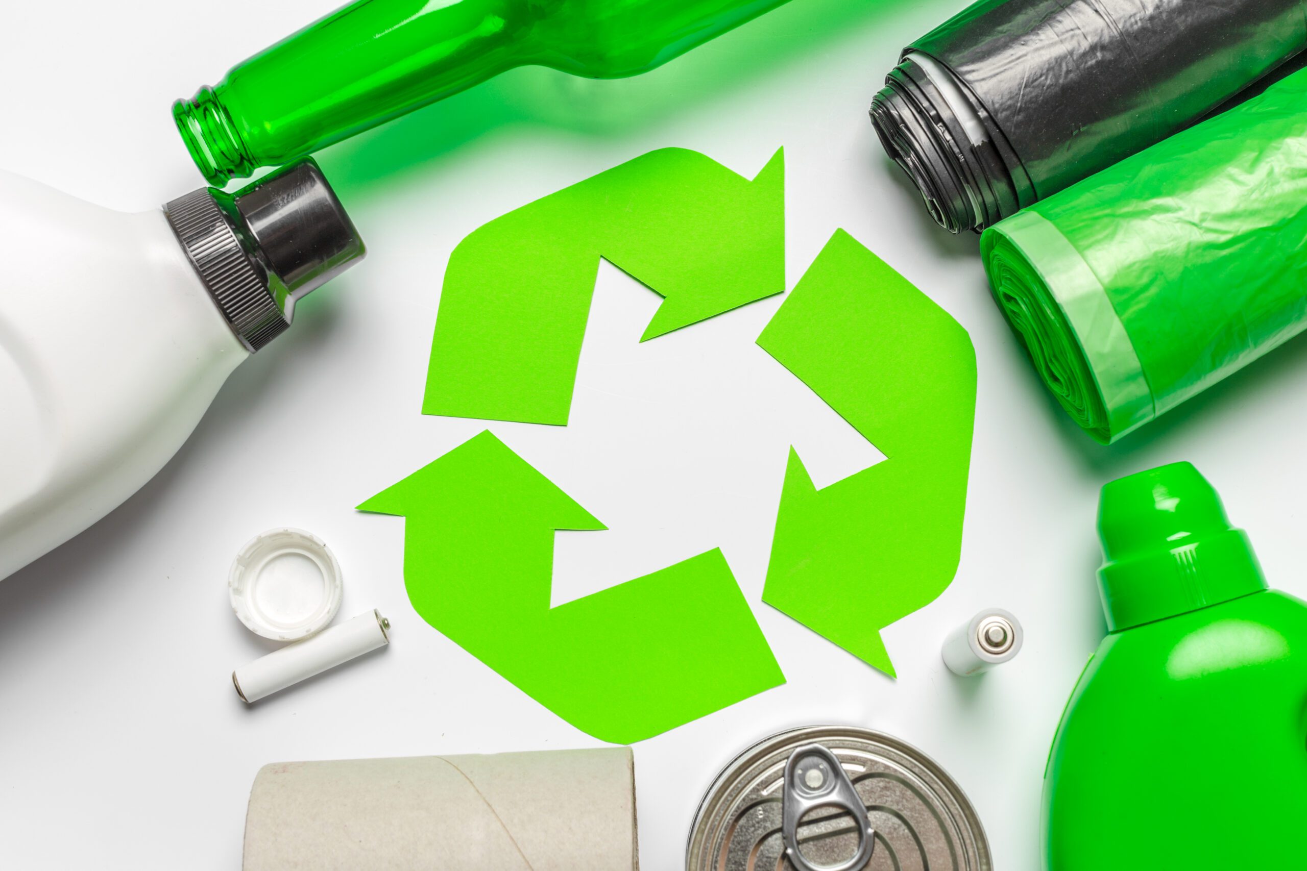 a green recycle symbol surrounded by garbage