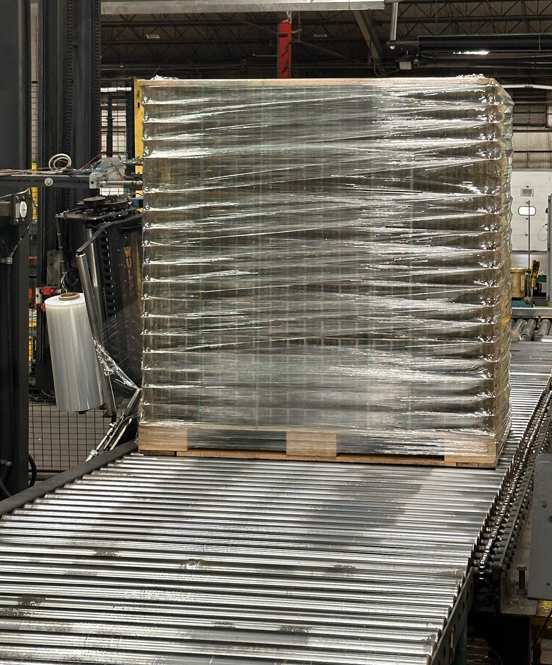 a pallet wrapped in plastic on a conveyor belt